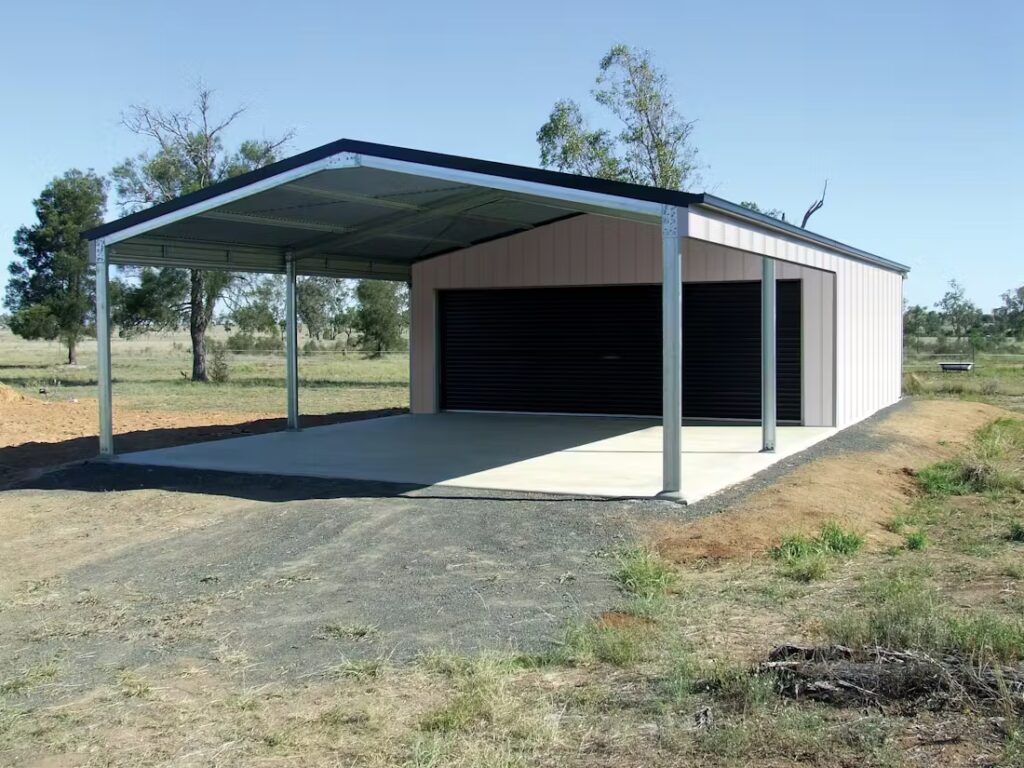 A metal carport with a concrete driveway in a rural setting.